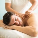 very relaxed young latin man getting deep tissue massage his back wellness spa clinic compressed 1 150x150
